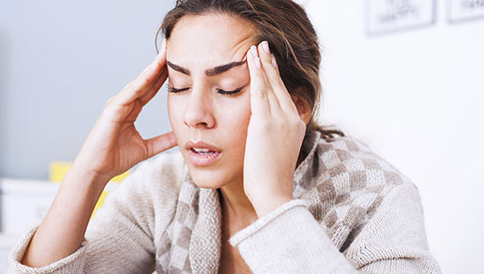 Woman suffering from headache before visiting Phoenix chiropractor